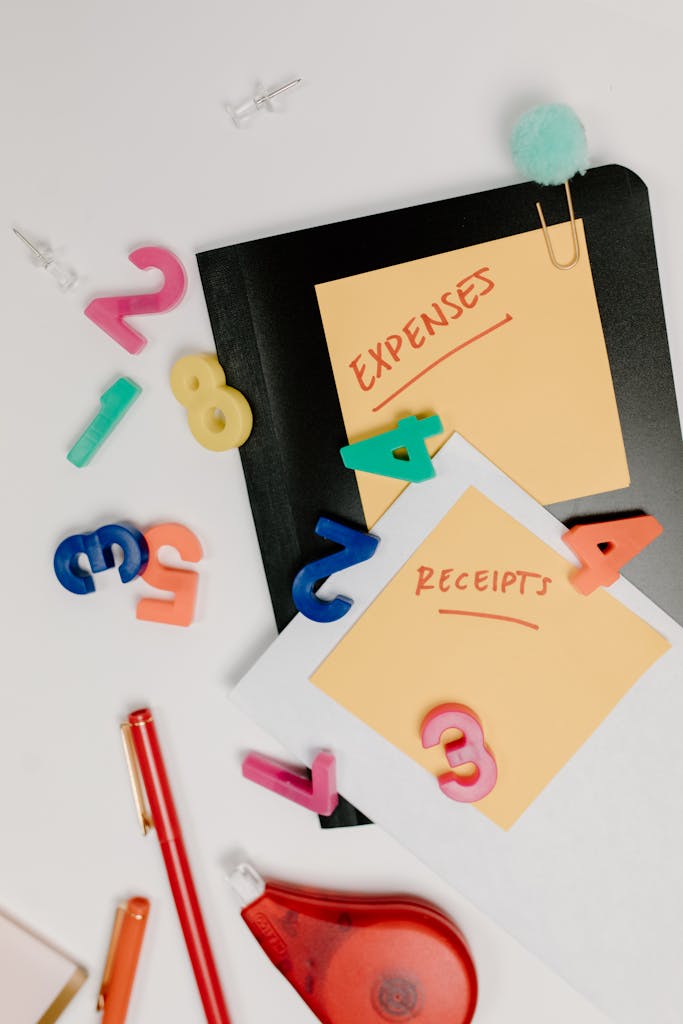 Flat lay of colorful office supplies and sticky notes labeled 'Expenses' and 'Receipts'.